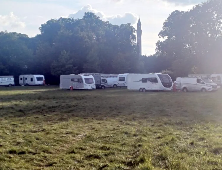 caravans and vehicles parked in field