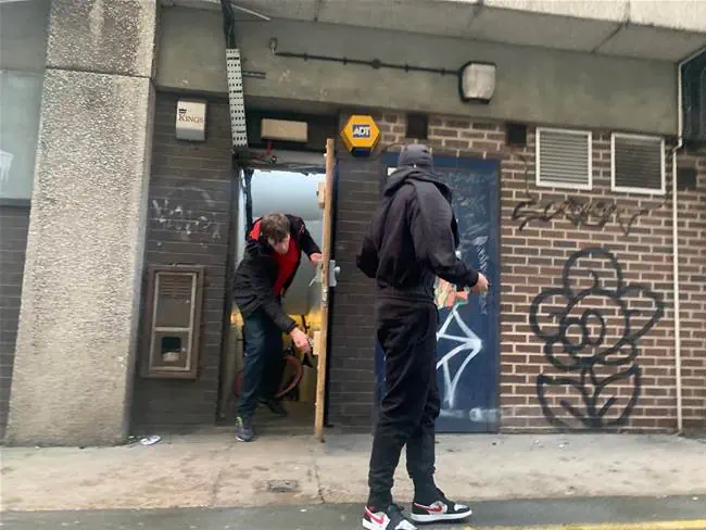 Squatters leaving stairwell of building omto pavement